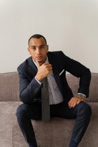 Caeser Abdalla, negotiation and communication coach, sitting in the boardroom in a suit reflecting on sustainable negotiation outcomes